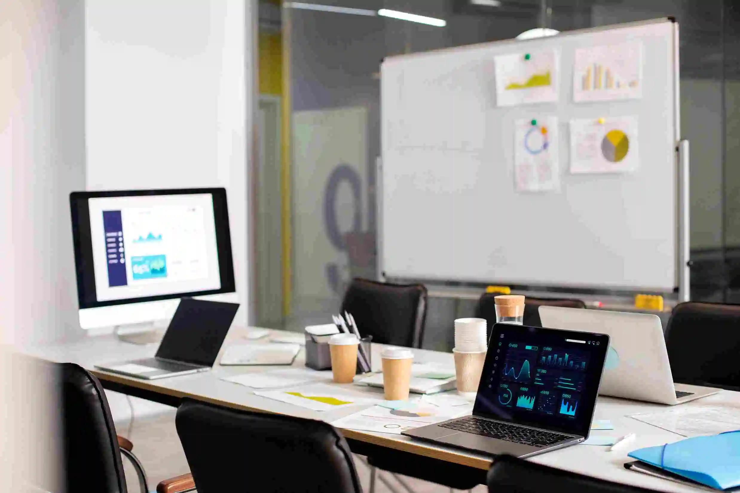 Workstation with analytics dashboards beside a project planning whiteboard
