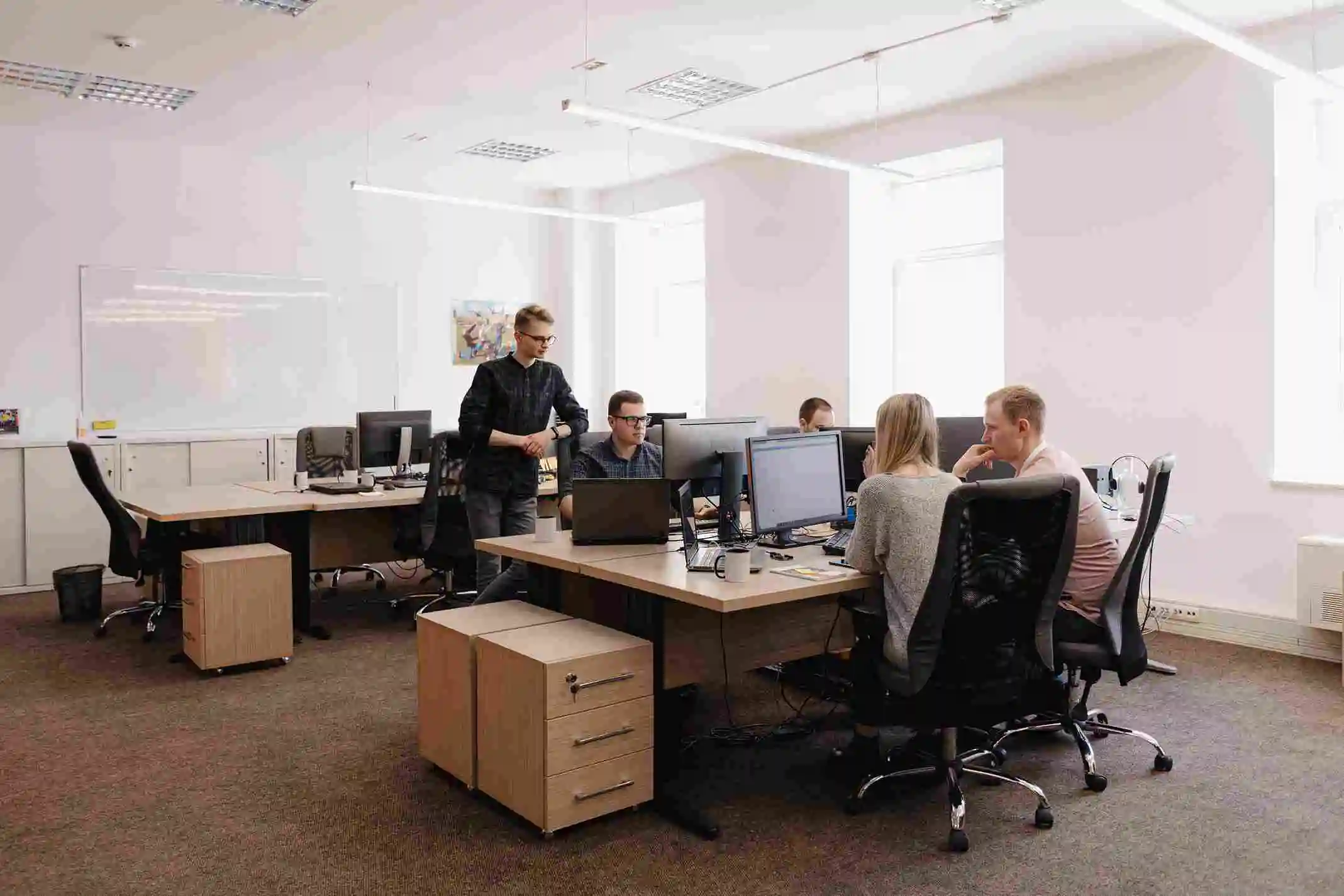 Team members working at desks in an open-plan office