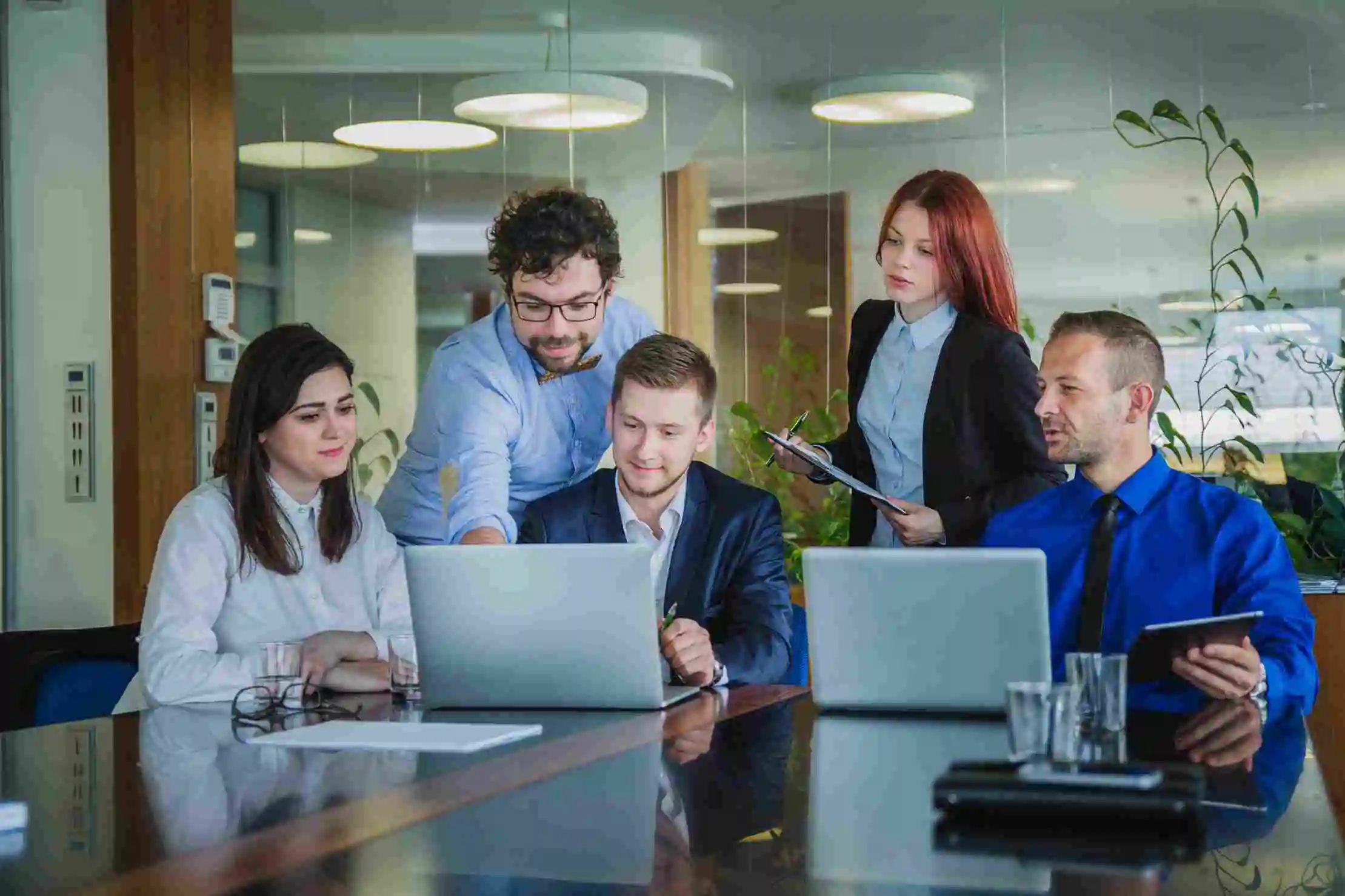 Team collaborating around laptops in a meeting